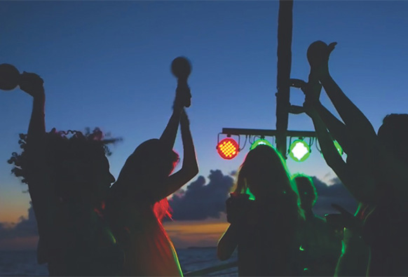 a group of people dance on a sunset cruise