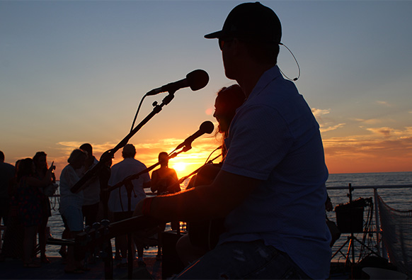 a band plays on a boat at sunset