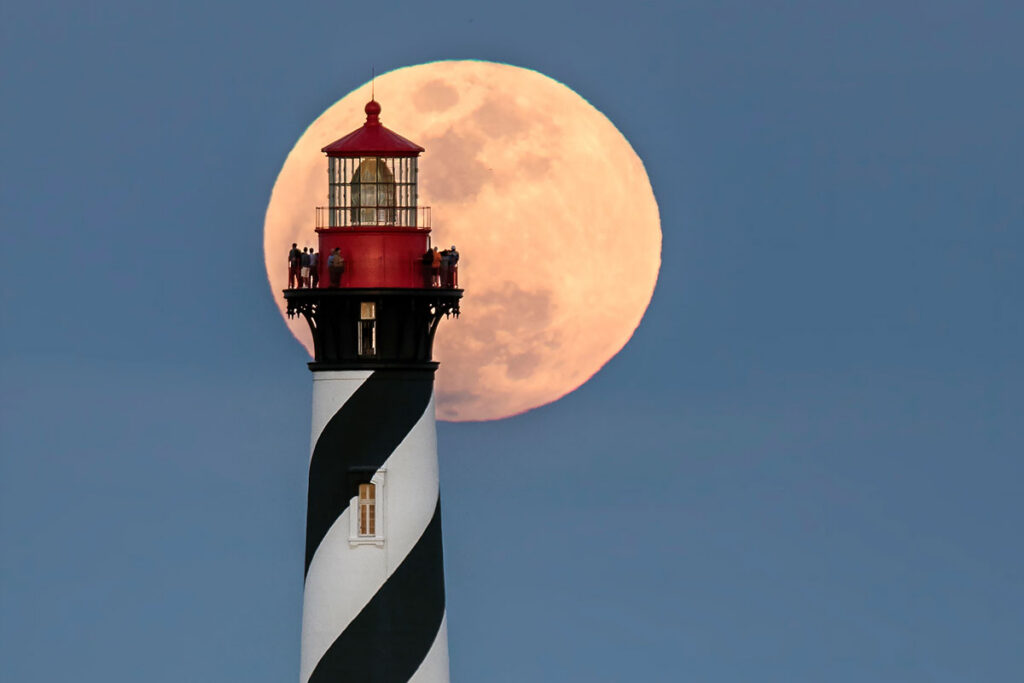lighthouse with moon in the background